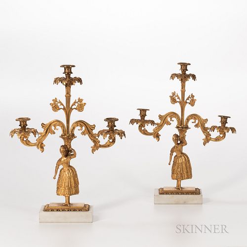 Pair of Gilt-bronze Jenny Lind Three-light Candelabra, each set on rectangular alabaster plinths, with twenty prism drops, eighteen com