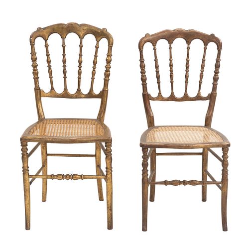 Par de sillas. SXX. Elaboradas en madera dorada. Con respaldos semiabiertos y asientos de bejuco.