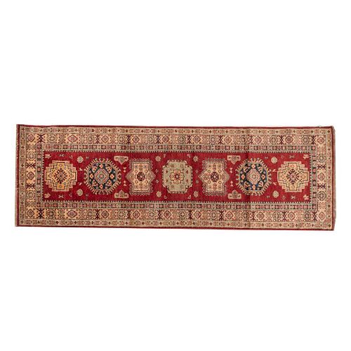 Tapete de pasillo. SXX. Estilo Kazak. Anudado a mano en fibras de lana. Decorado con elementos geométricos y florales. 233 x 75 cm