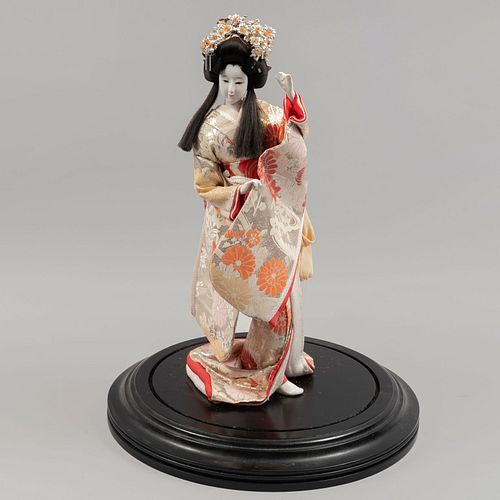 Geisha. Japón, SXX. Elaborada en resina. Decorada con indumentaria tradicional.  Con capelo de vidrio y base de madera.