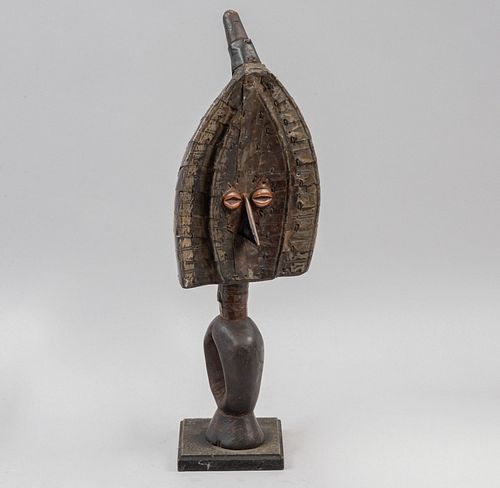 ANÓNIMO. África central, sXX. Escultura en madera con laminado en metal. 40 cm de altura.