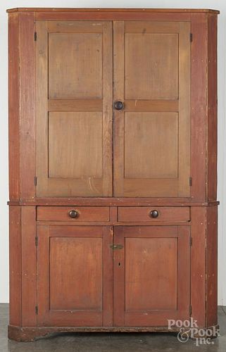Painted pine two-part corner cupboard, ca. 1830, retaining an old scrubbed red surface, 83'' h.