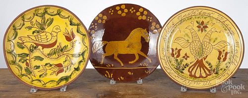 Three Breininger sgrafitto redware chargers, 12 1/4'' dia. Provenance: The Estate of Mark and Joan Eaby