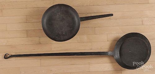 Two iron skillets, 19th c., 24 1/4'' l. and 49 1/2'' l.