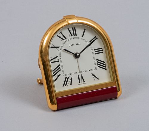 Reloj de mesa. Francia, sXX. De la firma Cartier Elaborado en metal dorado. Carátula blanca, índices romanos y manecillas tipo espada.