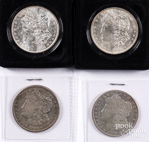 Four Morgan silver dollars.