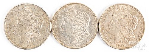 Three 1921 Morgan silver dollars, P, D, and S.