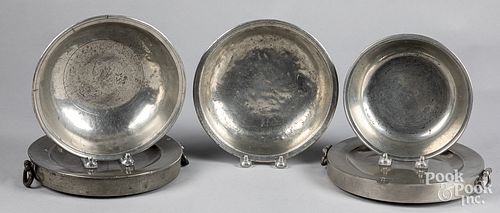 Two pewter warming plates, together with basins