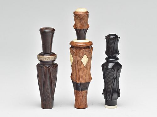 Three heavily carved duck calls.
