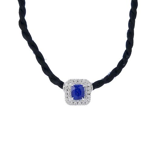 (193674) A sapphire and diamond pendant, on cord. The cushion-shape sapphire, within a brilliant-cut
