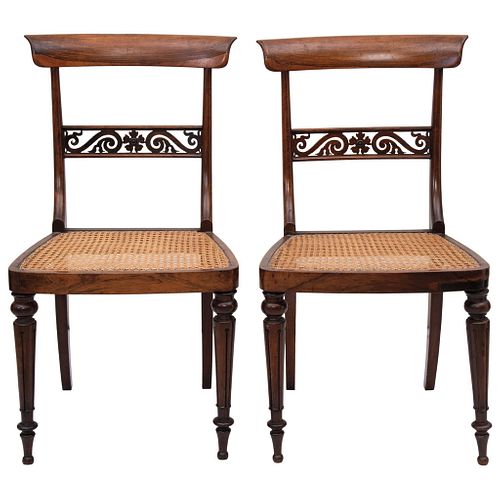 Par de sillas. Ca. 1900. En madera tallada, con asientos en bejuco.