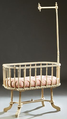 French Louis XVI Style Polychromed Beech Baby Crib, early 20th c., the cartouche shaped crib with a turned reeded mosquito netting hook on one end, on