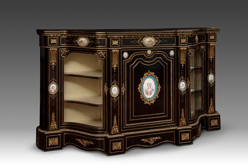Napoleon III style credenza, circa 1870. 
Ebonized wood, porcelain plates and bronze sconces. 
It presents restorations in the central plate and the k