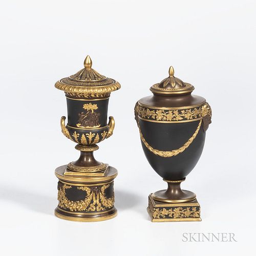 Two Wedgwood Gilded and Bronzed Black Basalt Vases and Covers, England, c. 1885, one with laurel festoons terminating at Bacchus heads below a vine bo