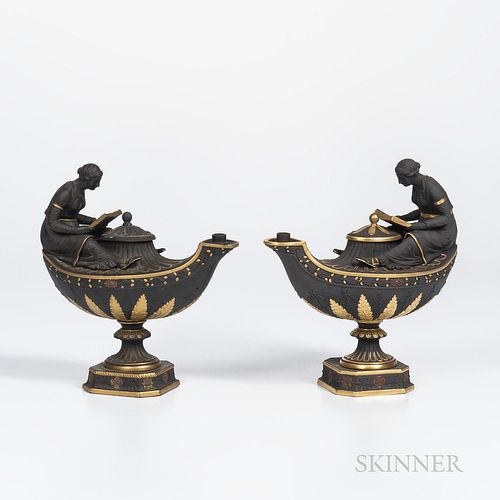 Two Wedgwood Gilded and Bronzed Black Basalt Oil Lamps and Covers, England, c. 1885, each oval, with fluted neck, oak leaf border and acanthus and bel