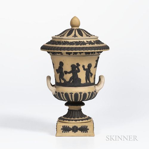 Wedgwood Yellow Jasper Dip Campana Vase and Cover, England, c. 1930, applied black jasper classical figures in relief below a fruiting grapevine band,