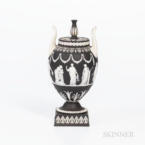 Wedgwood Black Jasper Dip Vase and Cover, England, late 19th/early 20th century, urn finial and upturned loop handles, applied white Muses in relief b