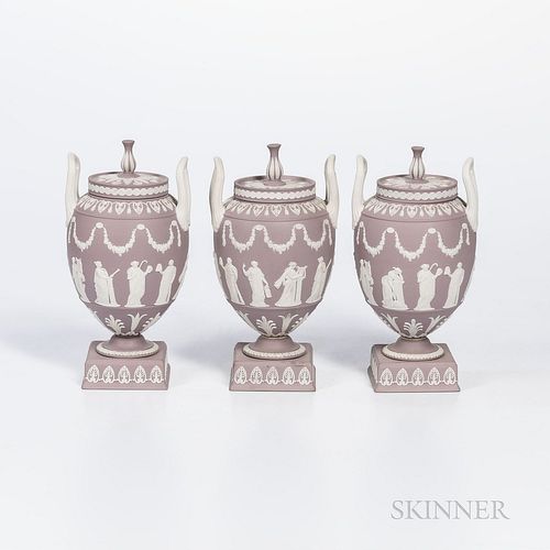 Three Wedgwood Solid Lilac Jasper Vases and Covers, England, c. 1960, each with applied white classical Muses in relief within foliate borders, upturn