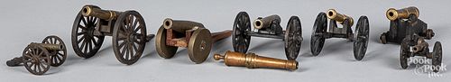 Seven iron and brass toy cannons, most souvenirs