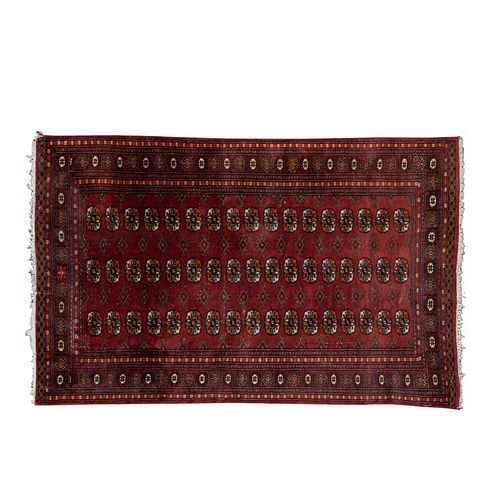 Tapete. SXX. Estilo Bokhara. Elaborado en fibras de lana y algodón en color rojo.