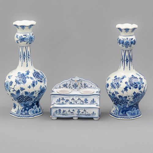 Guarnición. Países Bajos, SXX. Elaborados en porcelana Royal Bonn Delft. Consta de: 2 floreros laterales y tintero. Piezas: 3