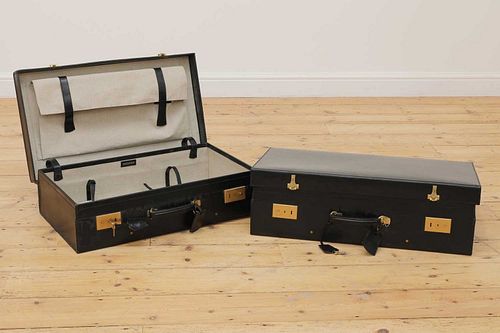 Two graduated black leather suitcases by Tanner Krolle,