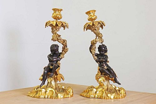 A pair of Napoleon III patinated bronze and ormolu candlesticks,