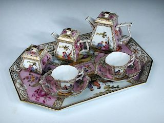 An early 20th century Crown Dresden tete a tete, each piece painted with pairs of figures in panels