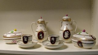 A late 18th/early 19th century Vienna porcelain part coffee service, each painted with grisaille pro