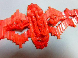 An Italian carved coral choker, designed with a central long oval feature with a fully modelled nake