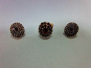 A Bohemian garnet cluster ring and a pair of matched earstuds, the ring with an oval cut pyrope garn