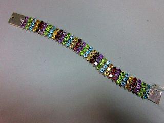 A multi gemset bracelet, composed of vertical lines of three round cut stones, alternating garnets,