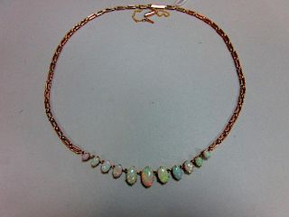 A graduated opal necklace, set to the front with an articulated line of eleven oval cabochon opals t