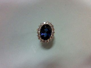 A large sapphire and diamond cluster ring, the oval cut deep blue sapphire, estimated weight 9.56cts