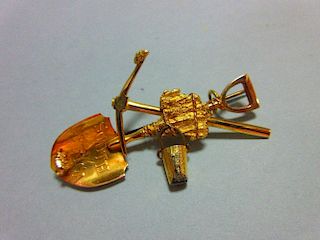 A South Africa gold rush brooch, with shovel, pick and free-swinging bucket tied together, the shove