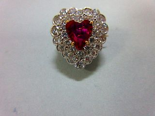 A ruby and diamond heart shaped brooch, with a heart cut ruby within a double row of pavé set round