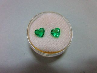 A pair of loose heart cut emeralds, the well-matched stones, suitable for earrings, of bright light