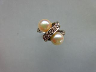 A Continental white gold, pearl and diamond crossover ring, the plain shank set to the front with ro