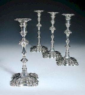 Two pairs of silver candlesticks, by Ebenezer Coker, London 1766/1767, each raised from a square mou