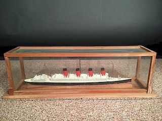 A mid 20th century painted wood model of a four-funnel passenger ship, mounted within a glazed hardw