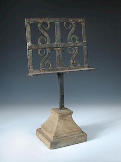 A 19th century wrought iron table lectern, the rectangular stand with applied s-scrolls and central