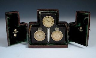 A Swiss leather cased desk timepiece with calendar and barometer, mounted with central silvered scal