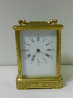 A small French gilt brass carriage timepiece, with floral scroll engraved case and 4.5cm rectangular