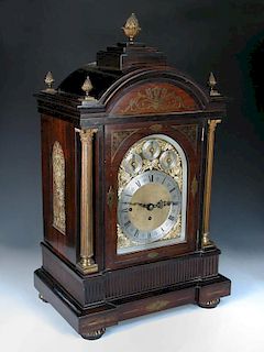 An imposing Victorian rosewood and brass inlaid chiming clock, the breakarch case with brass pineapp