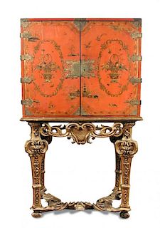 An 18th century Chinese red lacquer cabinet on a giltwood stand, decorated with a traditional river