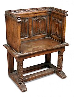 A Tudor revival oak pew seat, with castellated crest rail and linenfold panel back and sides, on car