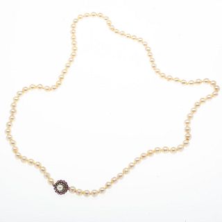 Collar de perlas y broche con rubíes en plata paladio. 89 perlas cultivadas color crema de 8 mm. Peso: 71.6 g.