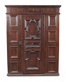 A 17th century Flemish oak panelled armoire, the frieze carved with monogram and date 1694, a centra