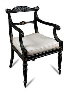 A Regency ebonised and gilt mounted elbow chair, with cane seat and squab, carved back, on gadroon m