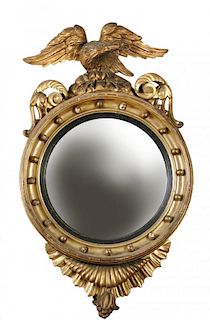 A Regency gilt framed convex mirror, with large eagle and scroll carved cresting, ball moulded frame